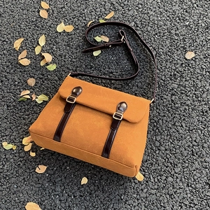 Vintage ginger faux suede tote bag with brown leather straps on autumn leaves background