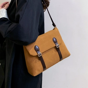 Brown frosted faux suede tote bag with leather straps and gold buckles on a model
