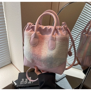Détail d'un sac seau rose avec patchwork en peluche coloré et poignées en cuir élégantes