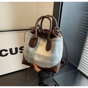 Vue détaillée du sac seau en peluche avec cuir marron et texture douce en fausse fourrure