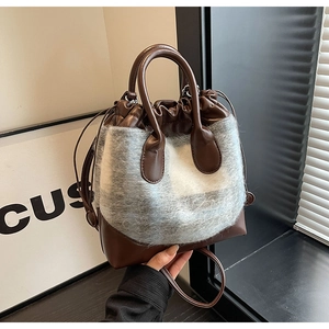 Détail du sac seau en peluche avec poignées en cuir marron et fermeture à cordon