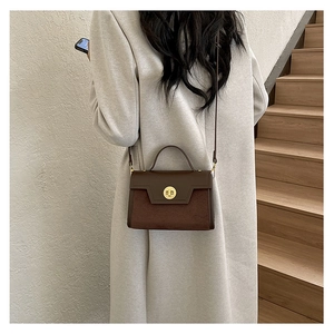 Detail shot of a vintage dark brown matte crossbody bag with a gold metal rotary lock
