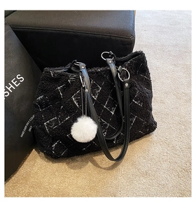Detail of black lambskin tote bag with white geometric patterns and faux fur ball