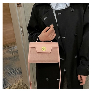 Detail of pink leather handbag with gold twist lock and adjustable shoulder strap