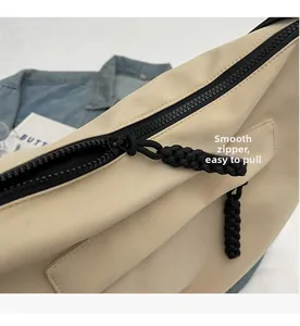 Detail shot of smooth black zipper and braided puller on a beige nylon tote bag