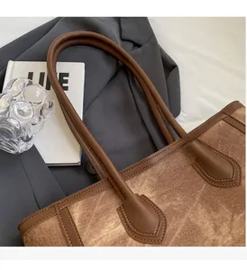 Detail view of brown vintage tote bag showing durable leather handles and fine stitching