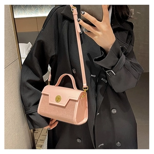 Detail of pink crossbody bag with metal twist lock and dual-texture leather finish