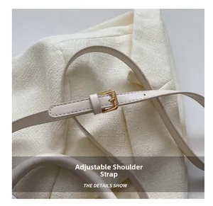 Détail de la bandoulière réglable en cuir crème avec une boucle en métal doré clair