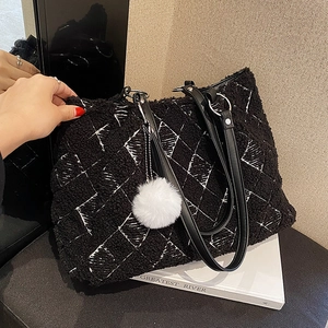 Large black lamb wool tote bag with white diamond patterns and plush ball accessory