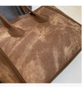 Detailed view of large brown tote bag with vintage texture and leather handles