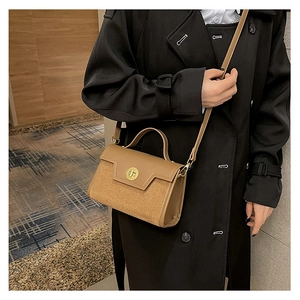 Detail of camel brown crossbody bag with gold metallic twist lock and smooth PU texture