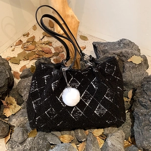 Black lamb wool tote bag with white geometric pattern and fluffy ball charm accessory