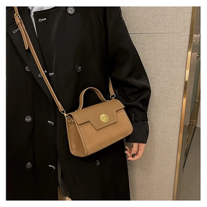 Brown vintage matte crossbody bag shown styled on a model wearing a long black coat