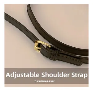 Détail de la bandoulière réglable en cuir noir avec boucle dorée et couture précise
