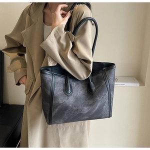 Detail of large textured tote bag in grey marble pattern with black leather trim