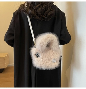 Detail of plush faux fur bucket bag featuring sparkly star patches and leather strap