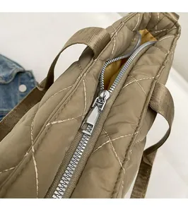 Dettaglio della cerniera argento e borsa tote in nylon trapuntato color kaki con cuciture