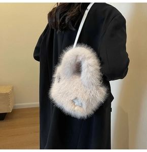 Detail of cream faux fur bucket bag with silver star sequins and leather shoulder strap
