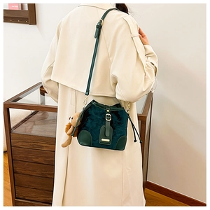 Sac seau vert foncé avec texture mate, bordure en cuir et joli pendentif d'ours brun