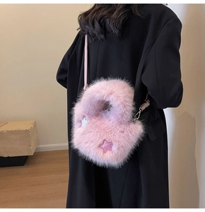Detail of pink faux fur bucket bag featuring glittery star patches and a slim shoulder strap