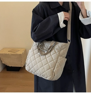 Dettaglio della borsa shopper trapuntata beige con trama a rombi e tracolla
