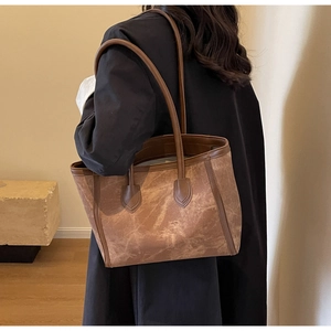 Detail of vintage brown tote bag with leather straps and retro textured material