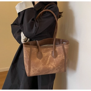 Detail of retro brown tote bag with marble texture and premium leather shoulder straps