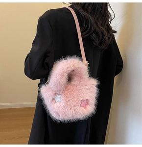 Detailed texture of pink faux fur bucket bag featuring sparkly star sequins and leather strap