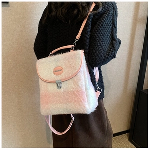 Detail of pink and white plush backpack showing metal buckle and soft fuzzy texture