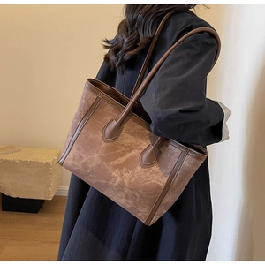Brown vintage tote bag shown in a side-view lifestyle shot on a model for size perspective