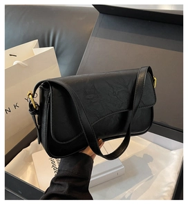 Detail view of black underarm bag with vintage wrinkled texture and gold D-ring buckle