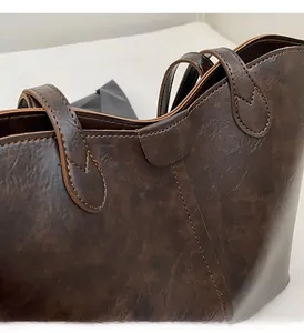 Detailed view of the dark brown leather tote bag showing fine stitching and vintage texture