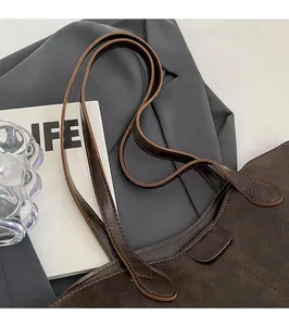 Detailed close-up of dark brown vintage leather tote with reinforced stitching