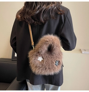 Detail of a brown fuzzy plush crossbody bag featuring decorative stars and a thin leather strap