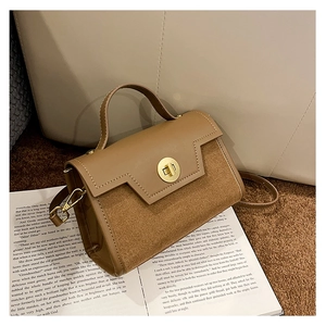 Close-up of retro crossbody bag with brown suede and leather texture on vintage book