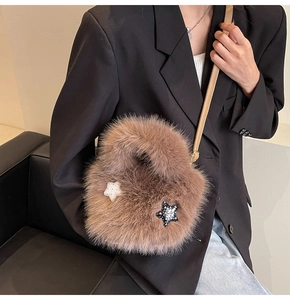 Detail of fluffy faux fur bucket bag with star patches and slim leather crossbody strap