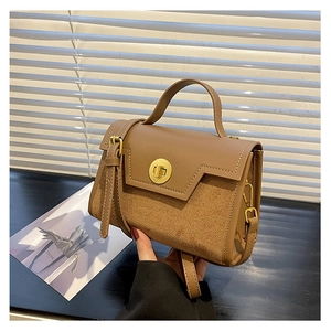 Detail of caramel faux leather shoulder bag with matte texture and gold swivel clasp