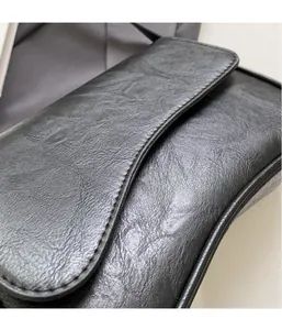 Detailed close-up of high-quality black faux leather with elegant pleated texture