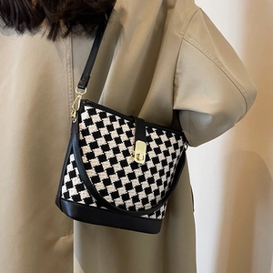 Sac seau à damier noir et blanc avec fermoir doré et bandoulière en cuir