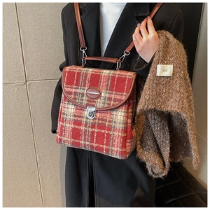 Detail of red-brown checkered tweed backpack with leather handle and silver metal buckle