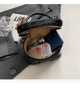 Interior view of black quilted bucket bag holding a smartphone and perfume bottle