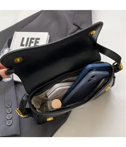 Interior view of large black saddle bag showing space for phones and cosmetics