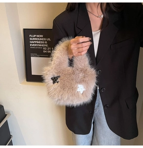 Close-up of light brown faux fur bucket bag featuring black and white star patches