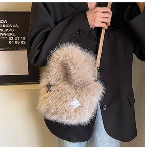 Detail of fluffy faux fox fur bucket bag with star charms and slim leather strap