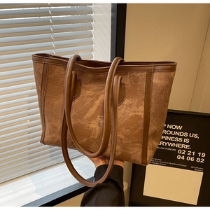 Detail view of large brown tote bag with premium leather trim and matte texture finish