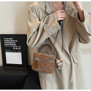 Brown quilted velvet crossbody bag with chain strap and plush bear charm detail