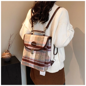 Close-up of pink tweed pattern texture and brown leather trim on the large backpack