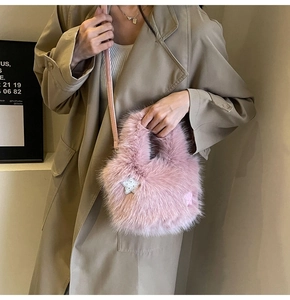 Close-up of pink faux fur bucket bag with star patches styled on khaki trench coat