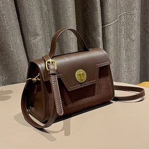 Retro brown suede and leather crossbody bag with golden clasp in a side 45-degree angle