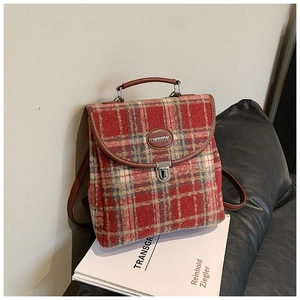 Close-up of red plaid tweed handbag featuring brown leather trim and silver metal lock